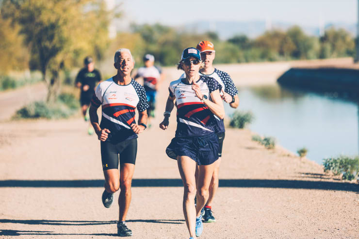 Three athletes run along a path. All three are wearing USA Triathlon Foundation shirts.